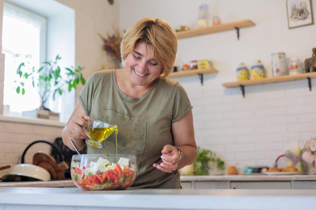 Une femme ménopausée cuisine une salade