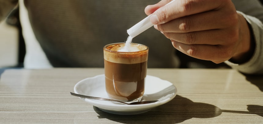 man ads some sugar to his machiatto, banner format