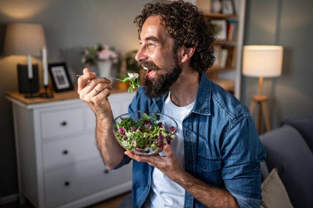 Homme mange de la salade
